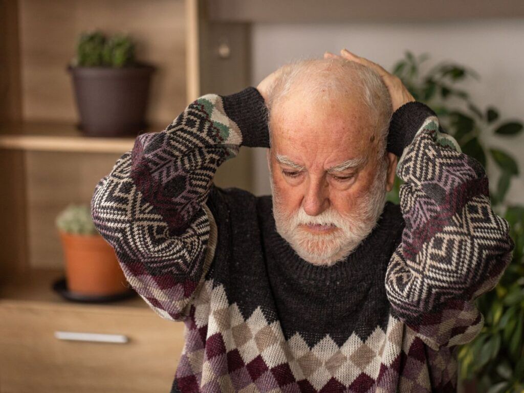 Senior man holding his head in confusion – memory care placement for Alzheimer’s and dementia support services in Los Angeles.