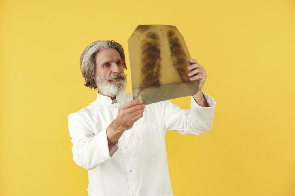 Doctor reviewing an x-ray while discussing spine curvature and scoliosis support for seniors.