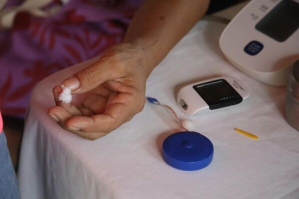 Close-up of a hand using a glucometer for diabetes monitoring, highlighting health awareness.