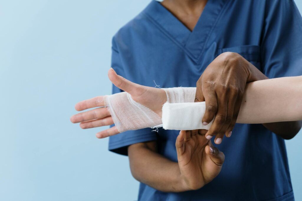 Medical professional gently wrapping an injured hand for senior hand pain support.
